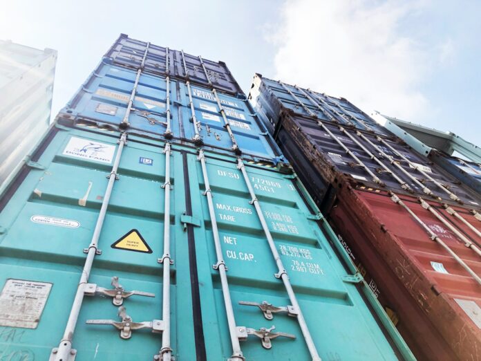 Photo by OSG Containers blue steel door under white clouds during daytime